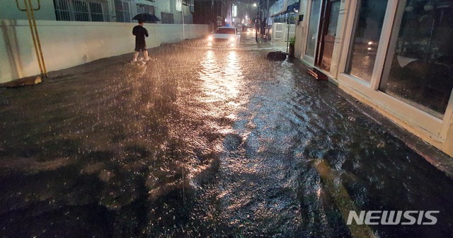 [부산=뉴시스] 하경민 기자 = 부산지역에 호우경보가 발효된 23일 오후 수영구의 한 주택가 이면도로가 침수돼 시민과 차량들이 힘겹게 이동하고 있다. 2020.07.23. yulnetphoto@newsis.com