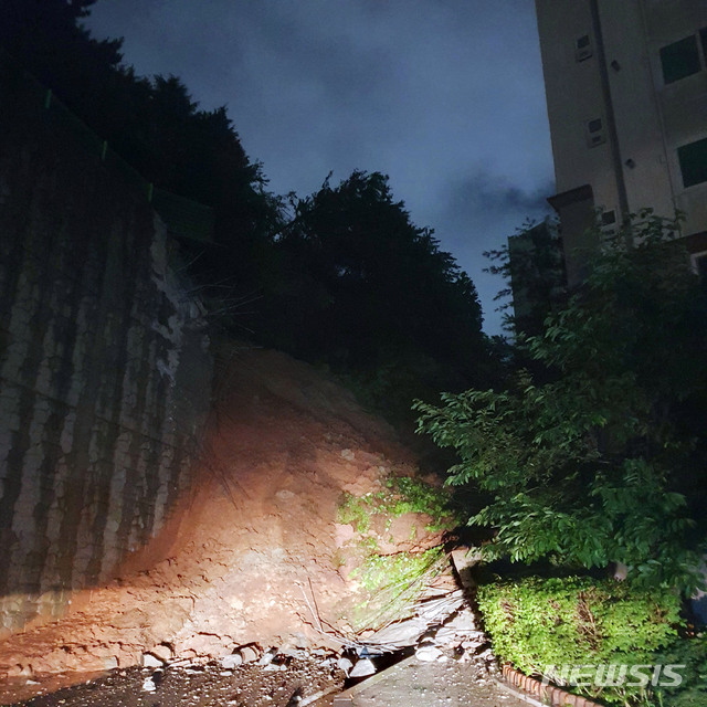 [부산=뉴시스] 부산지역에 호우경보가 발효된 23일 밤 금정구의 한 아파트 축대가 무너져 토사 20t 상당이 아파트로 쏟아졌다. (사진=부산소방재난본부 제공). 2020.07.24.  photo@newsis.com 