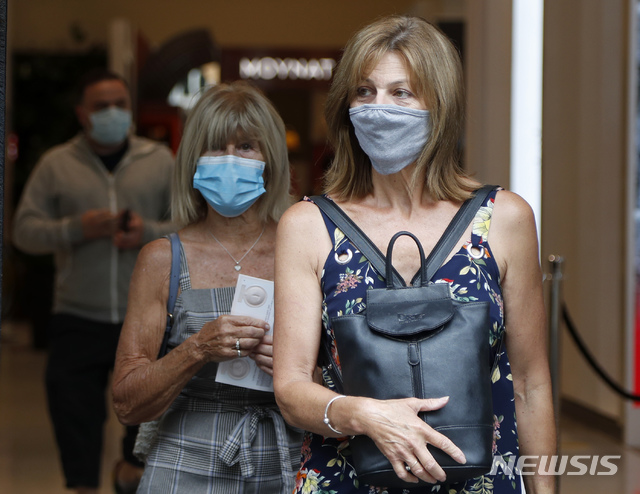 [런던=AP/뉴시스] 24일(현지시간) 영국 런던에서 쇼핑객들이 신종 코로나바이러스 감염증(코로나19)을 막으려고 마스크를 쓴 채 걷고 있다. 2020.07.27.