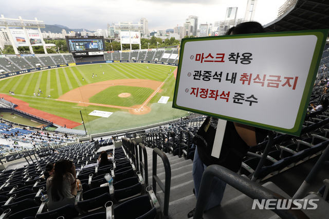 [서울=뉴시스] 고승민 기자 = 중앙재난안전대책본부의 프로스포츠 관중 입장 재개 발표에 따라 프로야구 경기부터 관중석의 10% 규모로 입장을 시작한 26일 서울 잠실야구장에서 관계자가 마스크 착용 등 메세지가 적힌 피켓을 들고 있다. 2020.07.26.kkssmm99@newsis.com