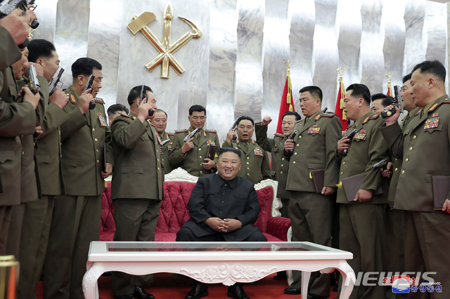 [평양=AP/뉴시스]북한이 26일 공개한 사진에 김정은(가운데) 북한 국무위원장이 평양의 당 중앙위원회 본부청사에서 열린 한국전쟁 정전협정 체결 67주년 기념행사를 주관하며 군 고위 간부들에게 '백두산' 기념 권총을 수여 한 후 기념촬영을 하고 있다. 2020.07.27.