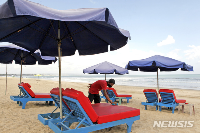 [발리(인도네시아)=AP/뉴시스]지난 7월27일 인도네시아 발리의 한 한적한 해변에서 노동자 1명이 내국 손님을 기다리며 의자를 청소하고 있다. 2020.08.25
