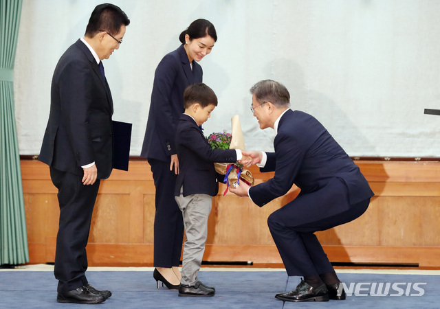 [서울=뉴시스]박영태 기자 = 문재인 대통령이 29일 청와대 본관에서 박지원 신임 국가정보원장에게 임명장을 수여한 후 박 국정원장의 손자에게 꽃다발을 주고 있다. 2020.07.29.since1999@newsis.com