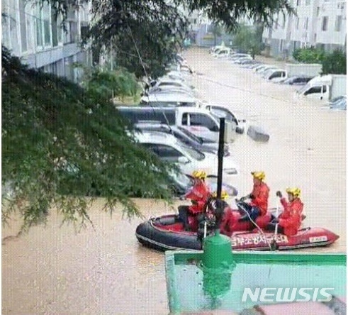 [대전=뉴시스] 갑짜기 불어난 물로 고립된 아파트 주민들을 구조하기 위해 소방대원들이 고무보트를 이용 접근하고 있다