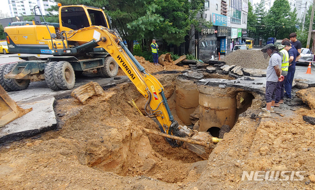 [전주=뉴시스] 김얼 기자 = 장마가 이어지며 전북지역에 많은 양의 비가 쏟아져 내린 30일 전북 전주시 완산구 평화로 일대에 큰 싱크홀이 생겨 관계자들이 복구작업을 하고 있다. 2020.07.30.pmkeul@newsis.com