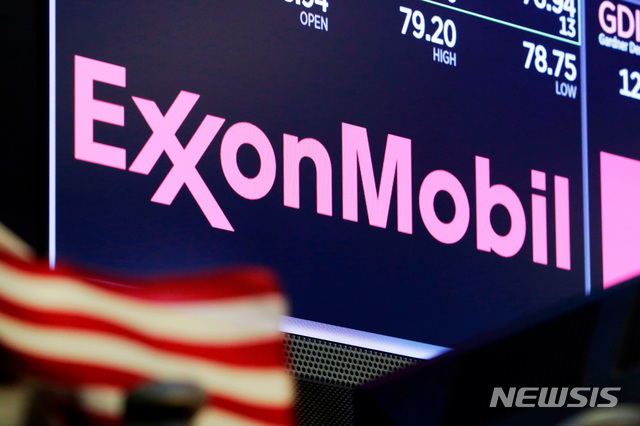 FILE - In this April 23, 2018, file photo, the logo for ExxonMobil appears above a trading post on the floor of the New York Stock Exchange. Exxon lost $1.1 billion in the second quarter, Friday, July 31, 2020, its economic pain deepening as the pandemic kept households on lockdown, diminishing the need for oil around the world. (AP Photo/Richard Drew, File)