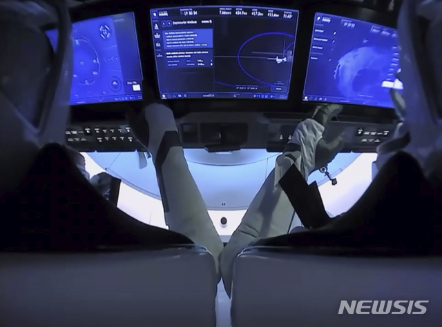 [NASA·AP/뉴시스] 미국 우주비행사 더글러스 헐리(왼쪽)와 로버트 벤켄이 1일(현지시간) 크루 드래건 캡슐에 앉아 국제우주정거장(ISS)과의 분리를 준비하고 있다 .두 비행사들은 2일 멕시코만 해상에 착륙할 예정이다. 2020.08,02