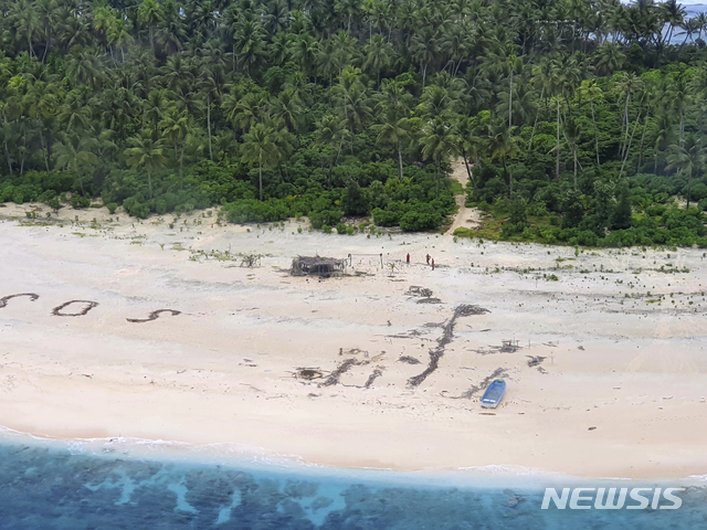 [피케럿=AP/뉴시스] 호주 서태평양에 있는 연방국 미크로네시아의 피케럿섬 해변에 SOS 글자가 보인다. 뒤편으로는 세 명의 사람이 서있는 모습도 보인다. 2020.8.4. 