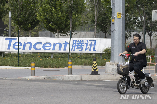 [베이징=AP/뉴시스] 8월7일(현지시간) 중국 베이징에 있는 텐센트 본사 앞을 한 남성이 자전거를 탄 채 지나가고 있다. 2020.08.14. 