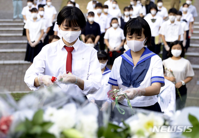 [나가사키=AP/뉴시스]나가사키 원폭 투하 75주년인 9일 일본 남부 나가사키의 원자폭탄 폭심지 공원에서 마스크를 쓴 고교생들이 헌화하고 있다. 2020.08.09.