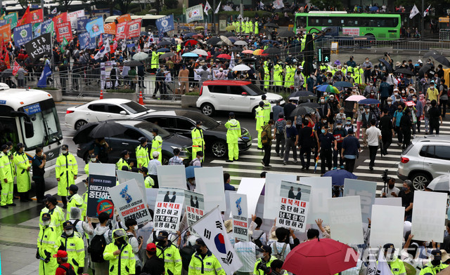 [서울=뉴시스]추상철 기자 =8·15 민족자주대회 추진위원회 회원들과 보수단체 참가자들이 지난 8월15일 오전 각각 서울 종로구 세종문화회관 앞에서 한미연합군사훈련 중단 등을 촉구하는 기자회견을 여는 한편 광화문광장에서는 보수단체 참가자가 집회를 하고 있다. 2020.08.15. scchoo@newsis.com