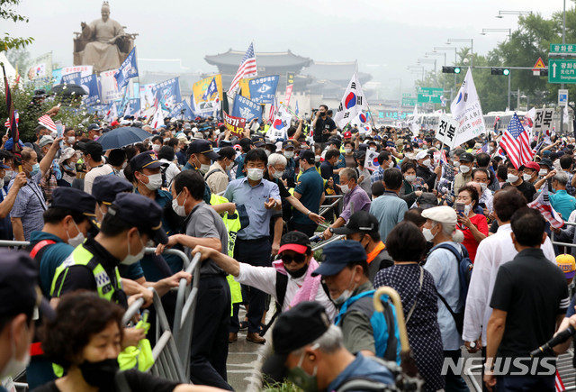 [서울=뉴시스]추상철 기자 =보수단체 집회 참가자들이 지난 15일 오전 서울 종로구 광화문광장에서 8·15 국민대회 집회를 벌이던 중 경찰이 세워놓은 바리게이트를 넘고 있다. 2020.08.15. scchoo@newsis.com