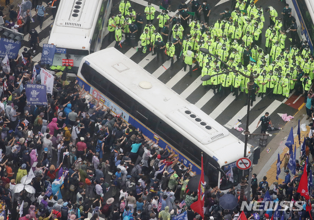 [서울=뉴시스]김명원 기자 = 15일 서울 종로구 광화문 광장 열린 보수단체 8·15 대규모 집회 참가자들이 경찰 저지선을 뚫고 사직로에서 청와대로 가는길로 몰려와 경찰들과 대치하고 있는 가운데 일부 집회 참가자들이 경찰 버스를 넘어트리려는 듯 밀고 있다. 2020.08.15.  kmx1105@newsis.com