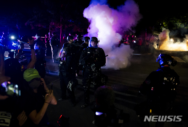 [ 포틀랜드( 미 오리건주)=AP/뉴시스] 포틀랜드 경찰이 16일 자정에 시위대를 향해 '폭동'을 선언한 뒤 최루가스와 고무탄 등 각종 진압장비를 총둥원해서 강제해산에 들어갔다.  