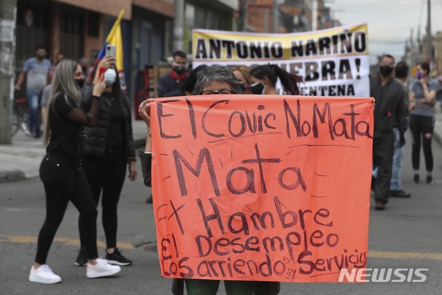 [보고타=AP/뉴시스]18일(현지시간) 콜롬비아 보고타에서 코로나19 확산을 늦추기 위해 시행한 보고타 시내 부분 폐쇄에 반대하는 시위가 열려 한 여성이 "코로나가 아닌 배고픔과 실업으로 죽겠다"라고 쓰인 팻말을 들고 있다. 시위대는 시 정부가 내린 봉쇄로 생계에 타격을 입고 근로권이 박탈됐다고 주장하고 있다. 2020.08.19.