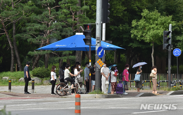 [안산=뉴시스] 김종택기자 = 폭염이 기승을 부린 지난 20일 오후 경기 안산시 단원구 고잔동 거리에서 시민들이 그늘막 아래 모여 신호를 기다리고 있다. 2020.08.20.semail3778@naver.com