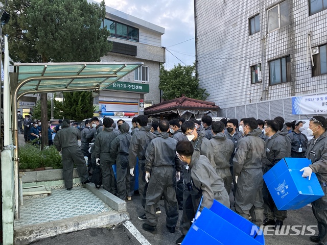 [서울=뉴시스]이기상 기자 = 서울 성북구 장위2동 주민센터 주차장에 모인 경찰들이 사랑제일교회 교인 및 방문자 명단 확보를 위한 압수수색 전 파란 상자 등을 꺼내 대기하고 있다. 2020.08.21. 