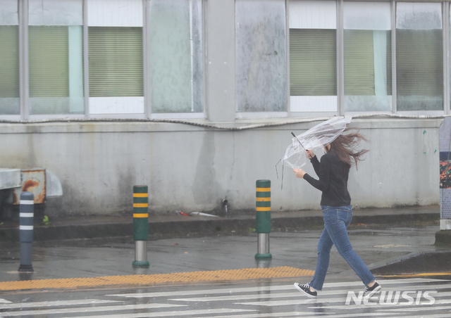 [서귀포=뉴시스]우장호 기자 = 한 시민이 바람에 꺾여버린 우산으로 비를 피하고 있다. 2020.08.26. woo1223@newsis.com