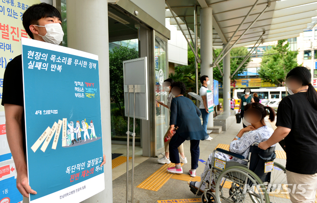 [광주=뉴시스] 김민국 인턴기자 = 26일 오전 광주 동구 학동 전남대병원 앞에서 한 전공의가 의대 정원 확대 등에 반대하는 손팻말 시위를 하고 있다. 2020.08.26. blank95@newsis.com