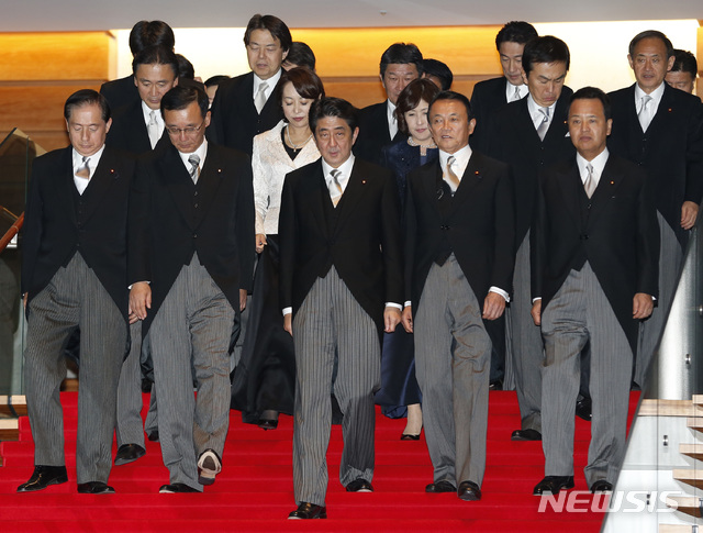[도쿄=AP/뉴시스]지난 2012년 12월 26일 일본 도쿄 총리 공관에서 2차 아베 내각 출범 후 사진 촬영을 하기 위해 각료들이 걸어가고 있다. 맨 앞 줄 가운데에 아베 신조 총리의 모습이 보인다. 아베 내각은 16일 총사퇴했다. 차기 내각을 이끌 스가 요시히데 총리의 모습이 마지막줄 가장 오른쪽에 보인다. 그는 7년 8개월 2차 아베 내각에서 계속 관방장관을 역임했다. 2020.09.16.