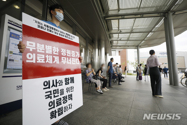 [서울=뉴시스] 고승민 기자 = 서울대병원이 외래진료를 축소하고, 전공의 등에 이어 교수도 집단 휴진에 나서는 것으로 알려진 31일 서울대병원에서 전공의가 피켓시위 및 유인물 배포를 하고 있다. 2020.08.31. kkssmm99@newsis.com