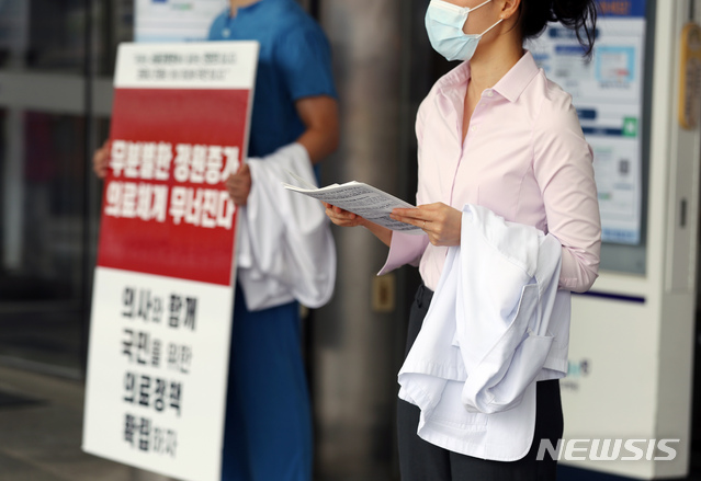 [서울=뉴시스] 고승민 기자 = 서울대병원이 외래진료를 축소하고, 전공의 등에 이어 교수도 집단 휴진에 나서는 것으로 알려진 31일 서울대병원에서 전공의가 피켓시위 및 유인물 배포를 하고 있다. 2020.08.31. kkssmm99@newsis.com