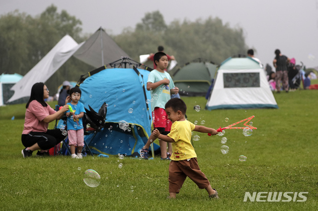  [베이징=AP/뉴시스]30일 중국 베이징 외곽 옌칭에서 사람들이 야영하는 가운데 한 아이가 비눗방울 놀이를 하고 있다. 중국 국가위생건강위원회는 전날 발생한 코로나19 신규 확진자는 17명이며 이들은 모두 해외에서 유입됐으며 중국 내 본토 감염 사례는 보름째 ‘0’을 기록하고 있다고 31일 밝혔다. 2020.08.31. 