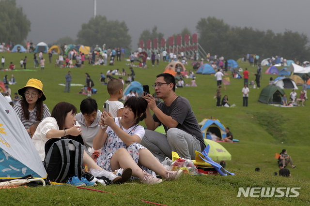 [베이징=AP/뉴시스]30일 중국 베이징 외곽 옌칭에서 야영을 즐기는 사람들이 휴대전화로 사진을 찍고 있다. 중국 국가위생건강위원회는 전날 발생한 코로나19 신규 확진자는 17명이며 이들은 모두 해외에서 유입됐으며 중국 내 본토 감염 사례는 보름째 ‘0’을 기록하고 있다고 31일 밝혔다. 2020.08.31.