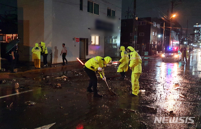 [부산=뉴시스] 제9호 태풍 '마이삭'(MAYSAK)의 영향으로 부산지역에 태풍경보가 발효된 2일 밤 영도구 남항동의 한 도로에 높은 파도가 덮친 이후 경찰이 해당 도로를 정리하고 있다. (사진=부산경찰청 제공). 2020.08.25.  photo@newsis.com 