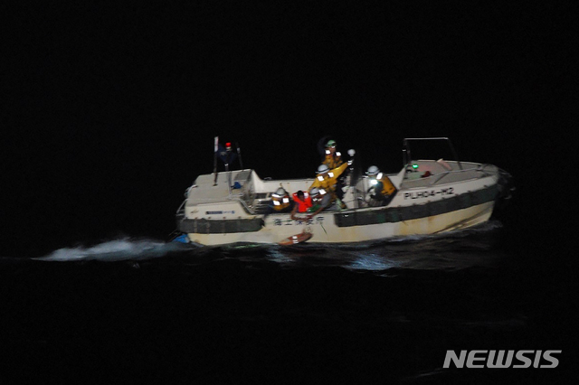 [AP/뉴시스] 2일 저녁 일본 해안경비대 구조선이 소 화물선 침몰 후 표류중이던 필리핀인 선원(빨간옷)을 구해 달리고 있다