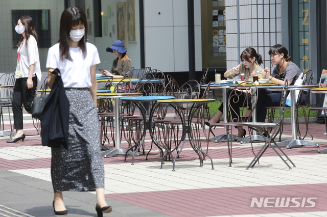 [도쿄=AP/뉴시스]15일 일본 도쿄에서 시민들이 야외 테이블에서 마스크를 벗고 점심을 즐기고 있다. 2020.09.15.