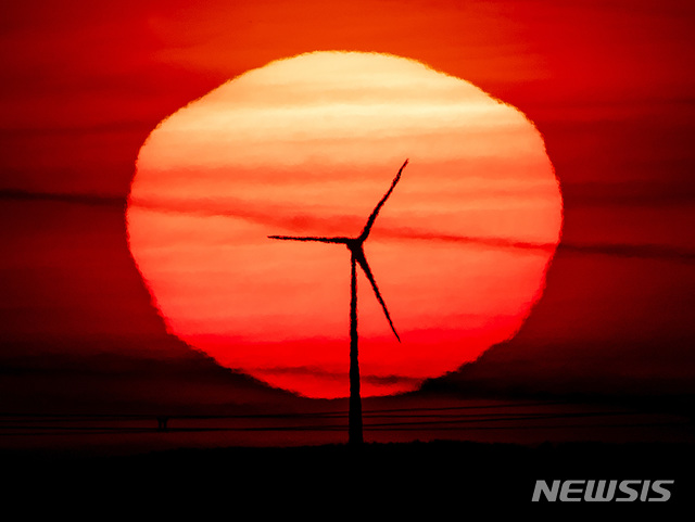 [프랑크푸르트=AP/뉴시스]15일(현지시간) 독일 프랑크푸르트에서 풍력 발전용 터빈 뒤로 해가 떠오르고 있다. 2020.09.15.