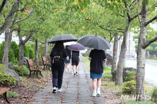 [제주=뉴시스] 양영전 기자 = 제주시 중앙여자고등학교 학생들이 우산을 쓴 채 교실로 향하고 있다. (사진=뉴시스DB) 0jeoni@newsis.com