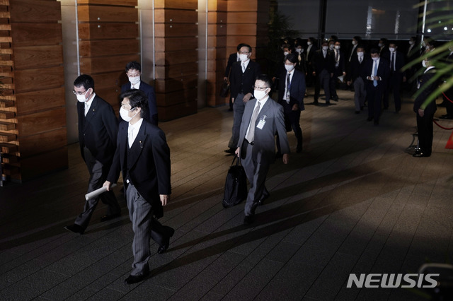 [도쿄=AP/뉴시스]스가 일본 신임 내각 각료들(왼쪽)이 16일 스가 요시히데(管義偉) 신임 총리의 각료 인증식에 참석하기 위해 총리 관저에서 일 왕궁으로 출발하면서 참모들의 호위를 받고 있다. 2020.9.16