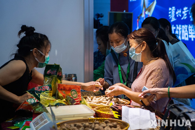 [창사=신화/뉴시스]중국 후난성 창사에서 지난 19일 중국국제음식조리박람회가 열린 가운데 사람들이 건식품을 구입하고 있다. 신종 코로나바이러스 감염증(코로나19) 예방을 위해 모두 마스크를 착용하고 있다. 2020.09.22.