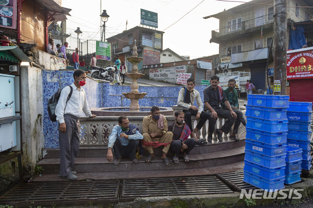 [다람살라=AP/뉴시스]23일(현지시간) 인도 다람살라에서 코로나19 확산 방지를 위해 마스크를 쓴 일용직 노동자들이 길가에 앉아 일거리를 기다리고 있다. 2020.09.23. 