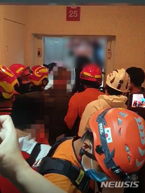 [부산=뉴시스] 부산 남구의 한 아파트 승강기에 갇혔다가 구조되는 모녀. (사진=부산경찰청 제공)