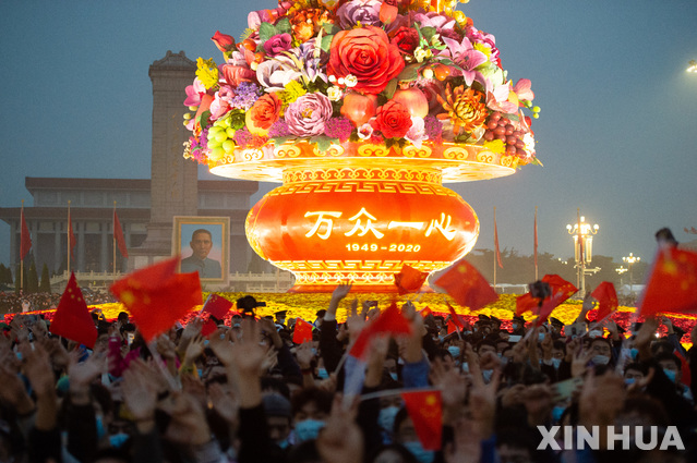 [베이징=신화/뉴시스] 중국 베이징 톈안먼 광장에서 1일 공산중국 수립을 축하하는 국경절을 맞아 열린 오성홍기 게양식을 지켜보기 위해 몰린 군중이 기념 조형물에 불이 들어오자 작은 깃발을 흔들며 환호하고 있다. 2020.10.01 
