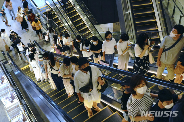 [도쿄=AP/뉴시스] 일본 도쿄 시내의 쇼핑센터에서 8월24일 코로나19 예방을 위해 마스크를 착용한 고객들이 에스컬레이터를 타고 이동하고 있다. 2020.10.02 