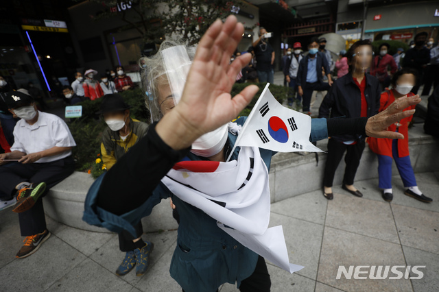 [서울=뉴시스] 고승민 기자 = 코로나19 전파 우려로 서울 도심 집회가 전면 금지된 지난 3일 서울 종로1가 인근 인도에서 한 시위자가 난동을 벌이고 있다. 2020.10.03.kkssmm99@newsis.com