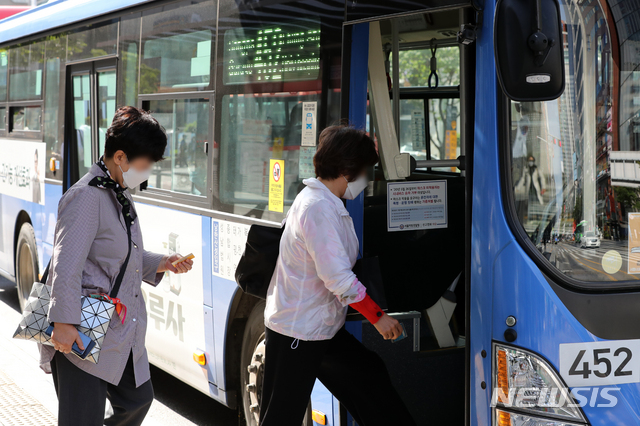 [서울=뉴시스]이윤청 기자 = 5일 서울 강남구 강남역 인근에서 시민들이 마스크를 쓰고 버스에 탑승하고 있다. 다음달 13일부터 마스크를 대중교통과 병원, 요양원, 집회시위장 등에서 쓰지 않으면 과태료 10만원이 부과된다. 2020.10.05.  radiohead@newsis.com