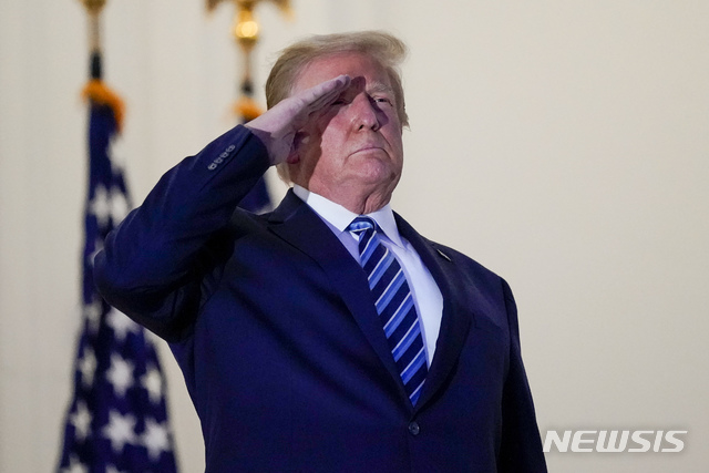 [워싱턴=AP/뉴시스]도널드 트럼프 미국 대통령이 지난 5일 월터 리드 국립 군 병원에서 백악관으로 돌아와 블루룸 발코니에 서서 전용 헬기 '마린 원'을 향해 경례하고 있다. 2020.10.31.