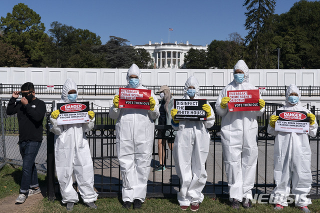 [워싱턴=AP/뉴시스] 지난 8일(현지시간) 미국 백악관 앞에서 보호복과 마스크, 장갑을 착용한 시위대가 신종 코로나바이러스 감염증(코로나19)에 항의하고 벌이고 있다. 2020.10.11.