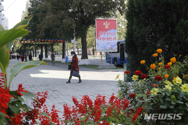[평양=AP/뉴시스]북한 조선노동당 창건 75주년을 맞은 10일 평양 시민들이 거리에 걸려 있는 '위대한 장군님은 우리 당의 영원한 수령'이라는 현수막 앞을 지나고 있다. 2020.10.10. 