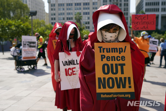 [로스앤젤레스= AP/뉴시스] 로스앤젤레스 시내의 여성행진 참가자들이 '트럼프-펜스, 아웃!"이란 팻말을 들고 행진하고 있다.   