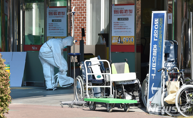 [광주(경기)=뉴시스] 김종택기자 = 신종 코로나바이러스 감염증(코로나19)이 집단 발생한 경기 광주시 SRC 재활병원에서 18일 오후 관계자가 확진자 이송을 하기위해 방역복을 착용하고 있다. 2020.10.18. jtk@newsis.com