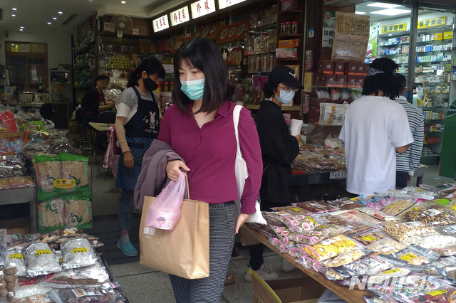 [타이베이=AP/뉴시스]19일 대만 타이베이의 한 시장에서 코로나19 확산 방지를 위해 마스크를 쓴 사람들이 물건을 살피고 있다. 2020.10.19.