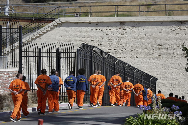 [샌 퀜틴(미 캘리포니아주)=AP/뉴시스] 캘리포니아주 샌 퀜틴 교도소에서 재소자들이 줄을 지어 이동하고 있다.  주 정부는 시설 정원을 초과한 교도소들이 많이 재소자를 최대한 줄이라는 대법원 명령에 따라서 앞으로 최고 종신형까지도 가석방자에 포함시켜 수 만명을 석방시킬 예정이다.  