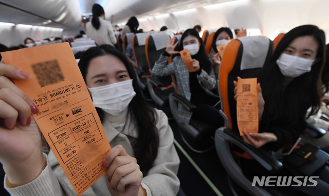 [인천공항=뉴시스] 공항사진기자단 = 제주항공 ‘인천 to 인천’ 관광비행 승객들이 23일 인천국제공항 1터미널에서 B737-800NG 항공기에 탑승해 이륙하기 전 항공권을 보이며 즐거워하고 있다. 이날 제주항공은 일반인을 대상으로 국내 상공을 선회한 뒤 복귀하는 관광비행을 진행했다. 2020.10.23.  photo@newsis.com