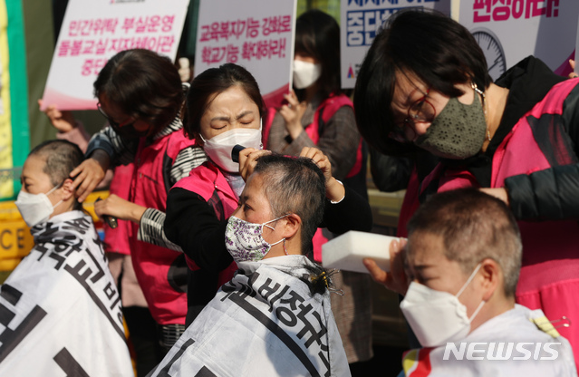 [서울=뉴시스] 고승민 기자 = 민주노총 서비스연맹 전국학교 비정규직 노조 회원들이 27일 서울 여의도 더불어민주당사 앞에서 11.6 돌봄파업 선포 및 초등돌봄전담사 집단삭발 기자회견을 하고 있다. 2020.10.27.kkssmm99@newsis.com